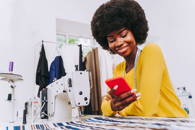 Fashion designer using mobile phone at studio