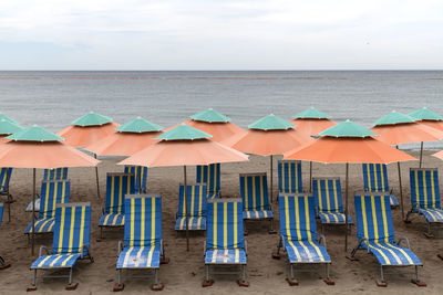 High angle view of lounge chairs on beach against sky