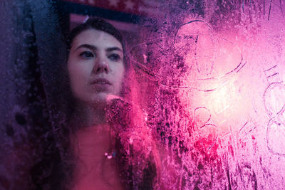 Close-up of woman behind frosted glass