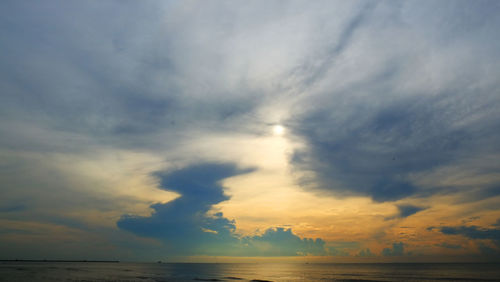 Sunrise sky with rain cloud at coastal beach in the morning.