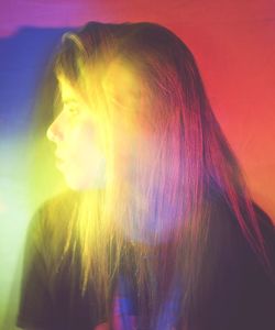 Portrait of young woman looking away against sky