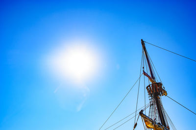 Low angle view of sailboat against blue sky