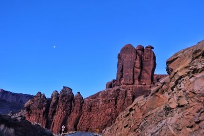 Low angle view of rock formation against clear blue sky