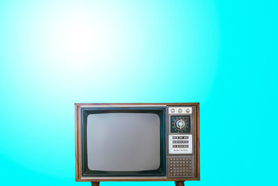 Low angle view of a clock against blue background