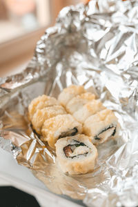 Japanese food delivery service rolls in plastic box and foil, hot and baked rolls, food 