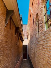 Low angle view of narrow alley amidst buildings