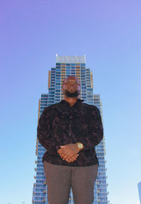 Low angle view of man standing against modern building