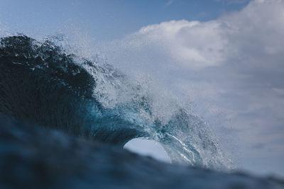 A powerful wave breaks under a cloudy sky in gran canaria, spain.