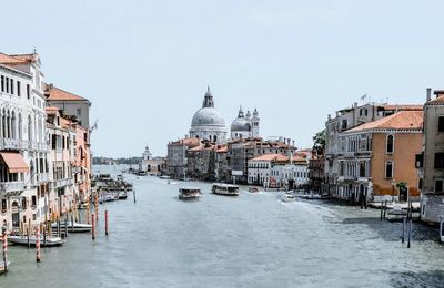 View of canal amidst buildings against clear sky