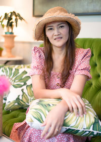 Portrait of a smiling young woman sitting in hat