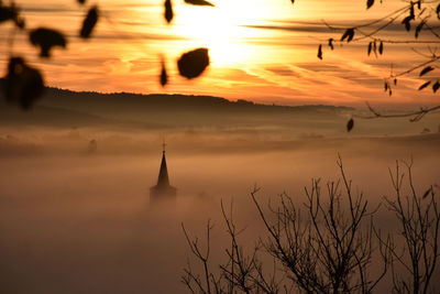 Scenic view of landscape in foggy weather during sunrise 