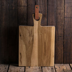 Close-up of cutting board by wooden wall