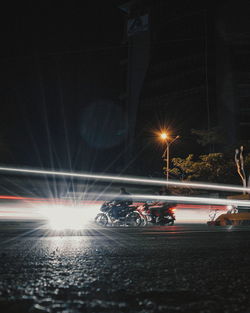 Light trails on road against sky at night