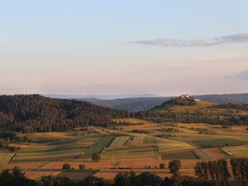 Scenic view of agricultural field against sky during sunset