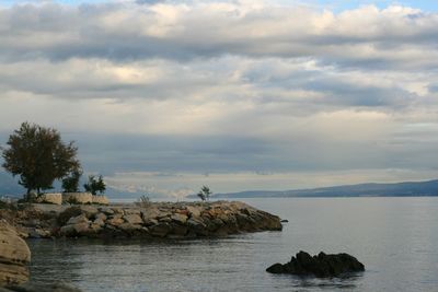 Rocks by sea against sky