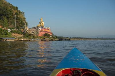 Traditional building by sea against sky