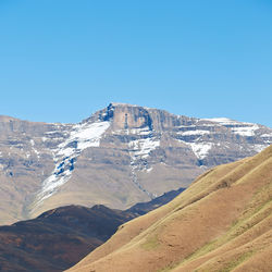 Scenic view of snowcapped mountains against clear blue sky