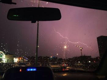 View of city through car windshield during rainy season