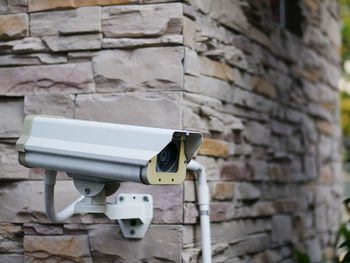 Close-up of camera against brick wall