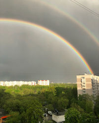 Scenic view of rainbow over buildings in city