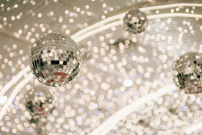 Low angle view of disco balls against christmas lights