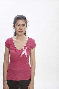 Woman wearing breast cancer awareness ribbon against white background