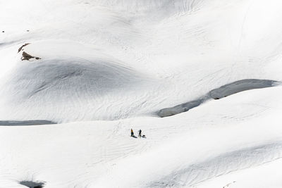 Two unrecognizable people in a snowy mountains practicing wintersport