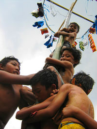 Low angle view of young woman against sky