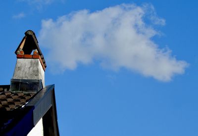 Low angle view of house against blue sky on sunny day