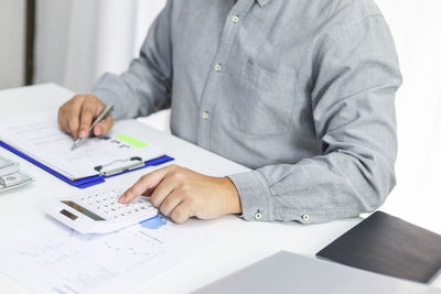 Midsection of man working on table