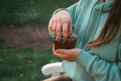 Midsection of woman holding berries in container