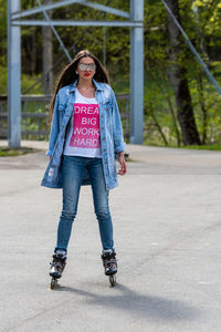 Full length portrait of teenage girl standing on road