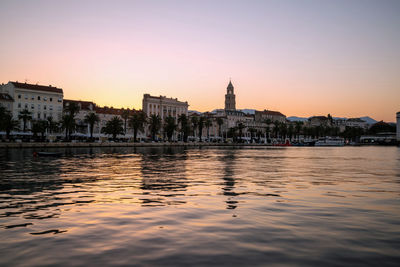 Reflection of buildings in city at sunset