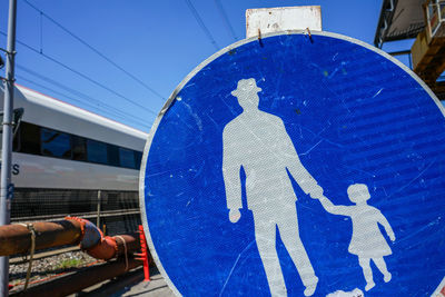 Low angle view of sign against blue sky