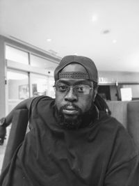 Portrait of man wearing eyeglass sitting indoors