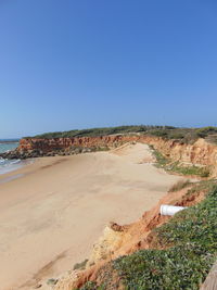 Scenic view of beach against clear blue sky