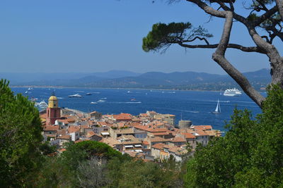High angle view of city by sea against clear sky