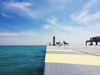 View of pier on sea against blue sky