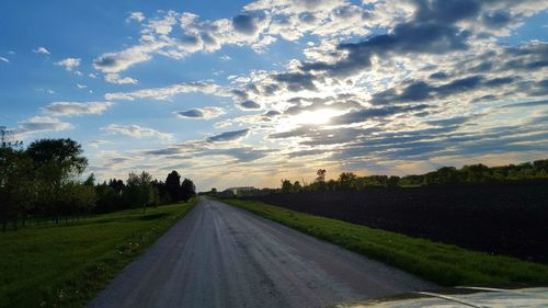 Country road against cloudy sky