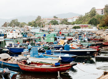 Boats moored in harbor by buildings in city