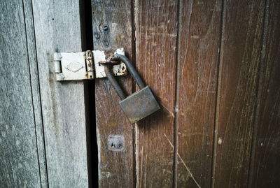 Close-up of padlock on wooden door