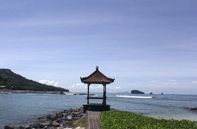 Lifeguard hut on beach against sky