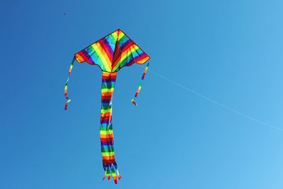 Low angle view of colorful balloons against clear blue sky