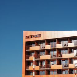 Low angle view of apartment building against blue sky