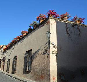 Low angle view of buildings against clear blue sky