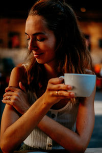 Close-up of woman drinking coffee in cafe