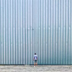 Rear view of man standing against wall