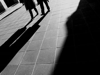 Low section of woman walking on tiled floor