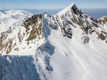 Scenic view of snow covered mountains against sky