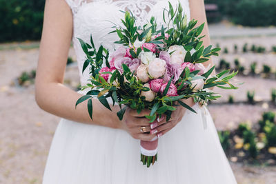 Midsection of woman holding flower bouquet